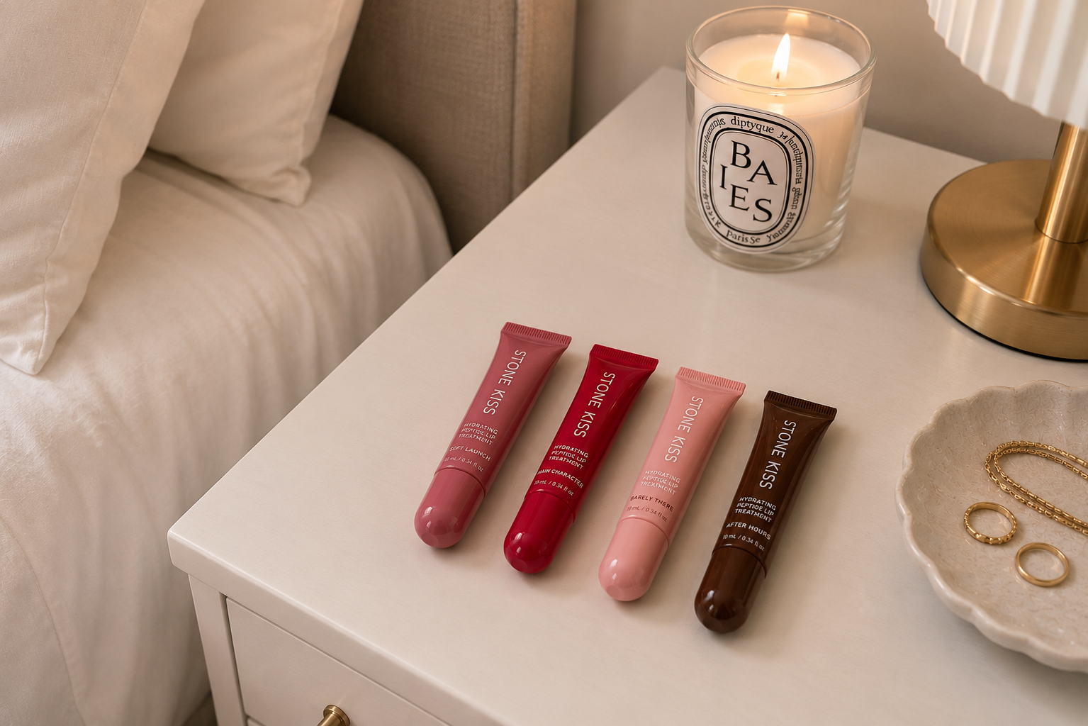 Stone Kiss hydrating peptide lip treatment — four shades on a bedside table
